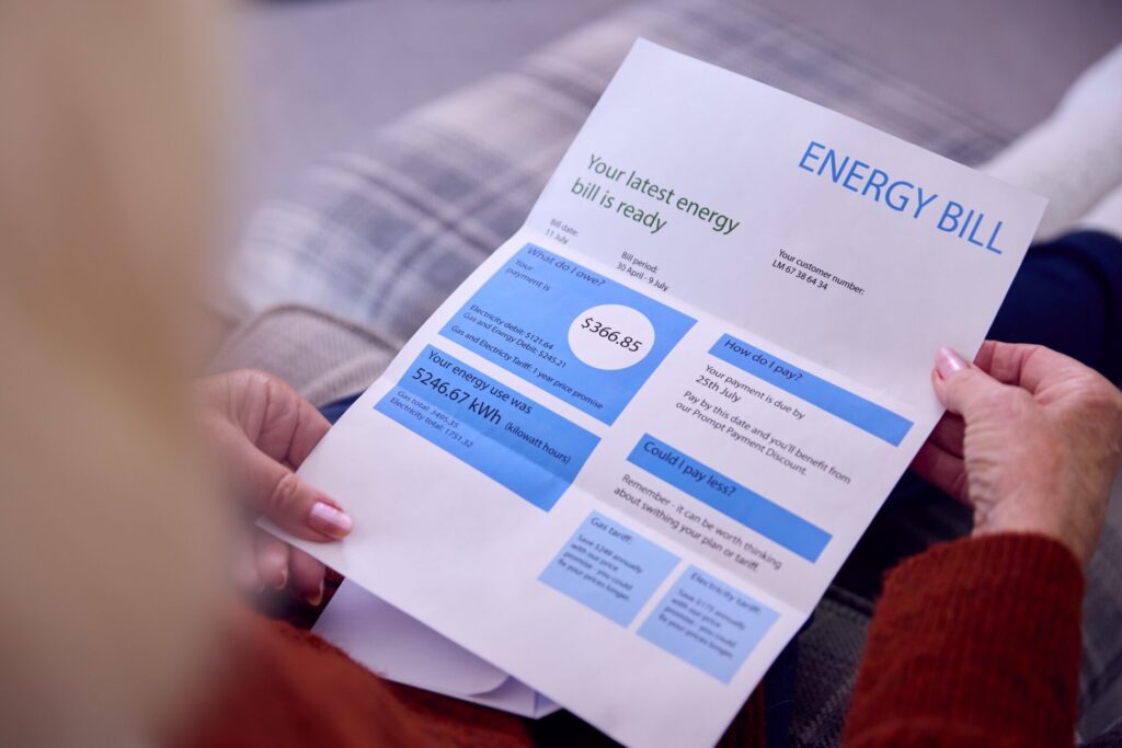 A close-up image of an energy bill in an older woman’s hands.