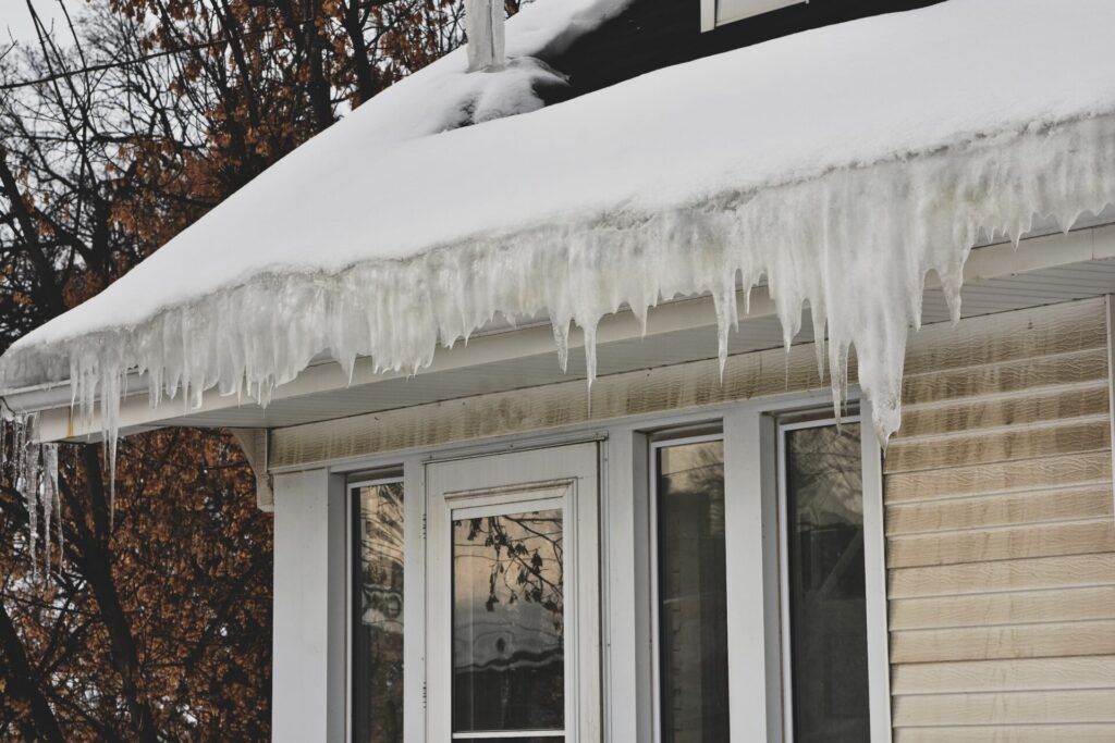 A home with vinyl siding with thick icicles hanging from the roof